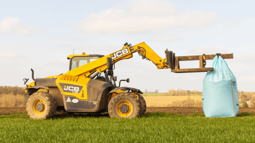 Yellow telehandler with extended boom on a construction site used in Telehandler Ticket training