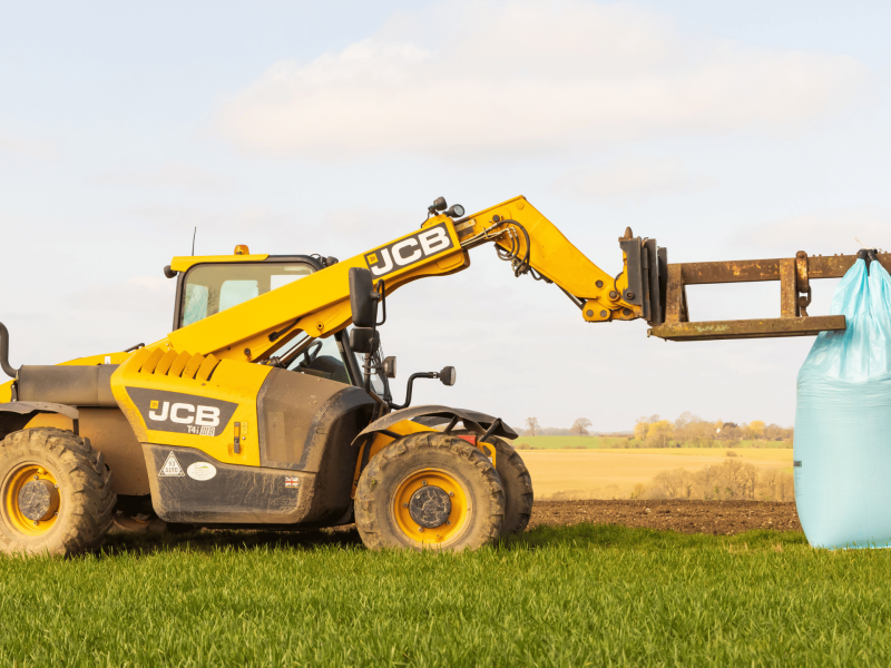 Yellow telehandler with extended boom on a construction site used in Telehandler Ticket training